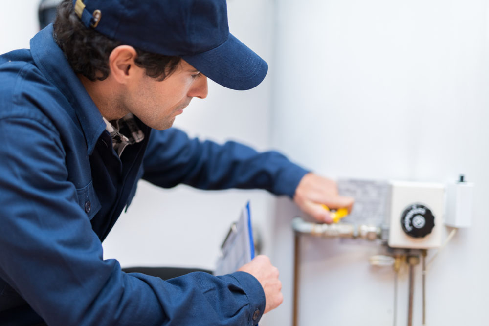 technician inspecting a water heater