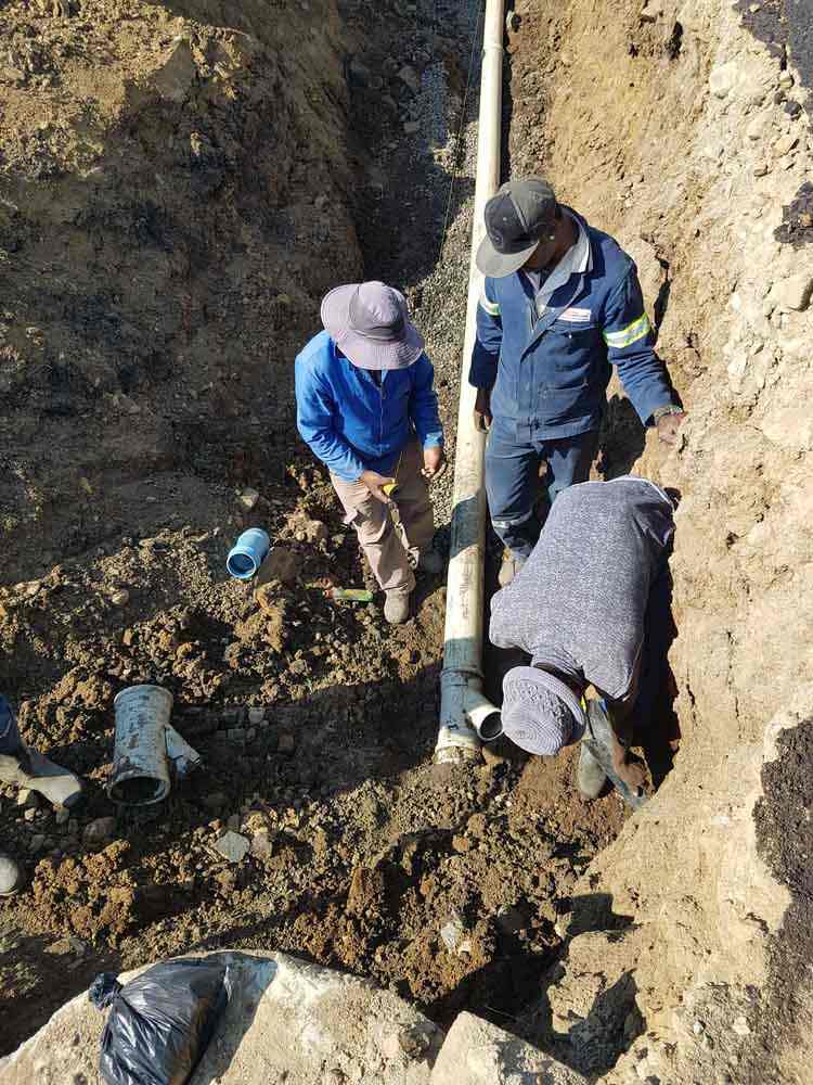 technicians excavating an underground sewer line